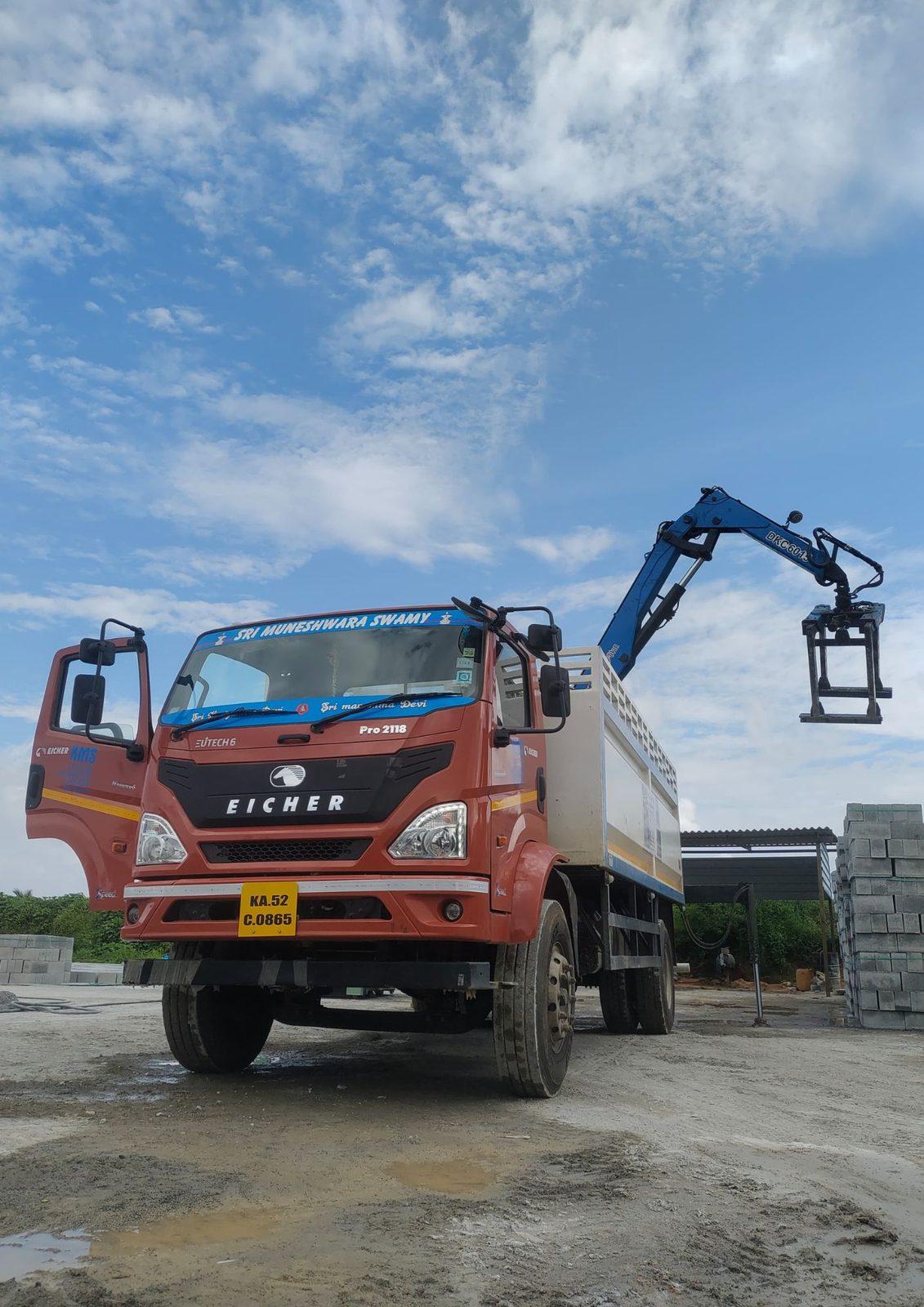 Crane-mounted brick grabber on a truck at a block yard