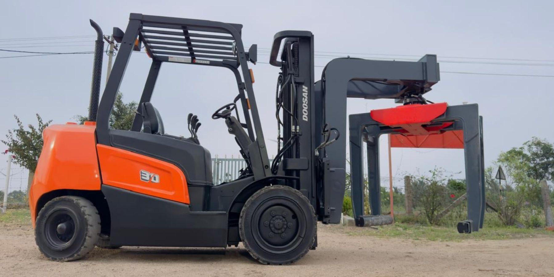 SAE 03 frame-mounted high-lift brick grabber on an orange forklift