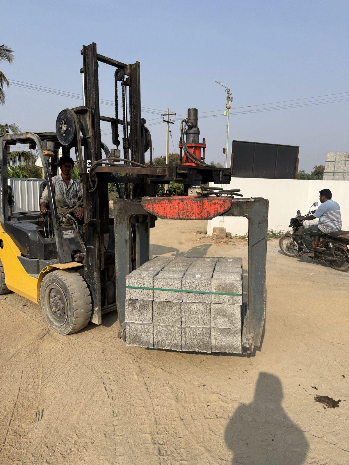 SAE 01 brick grabber holding a stack of blocks on a forklift in a block yard